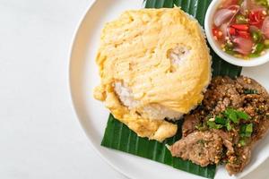 Huevo sobre arroz con cerdo a la parrilla y salsa picante - estilo de comida asiática