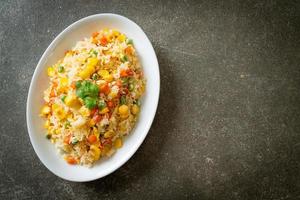 arroz frito casero con vegetales mixtos de zanahoria, guisantes, maíz y huevo foto