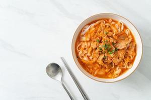 Korean udon ramen noodles with pork in kimchi soup photo