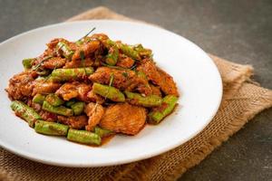 Stir fried pork and red curry paste with sting bean photo
