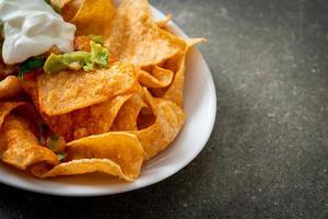 nachos mexicanos tortilla chips con jalapeño, guacamole, salsa de tomate y dip foto