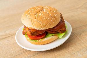 Grilled chicken burger with sauce on white plate photo