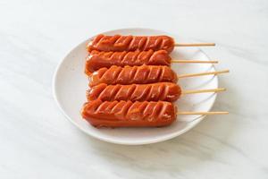 Fried sausage skewer on white plate photo