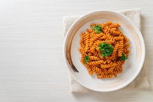 Spiral or spirali pasta with tomato sauce and sausage - Italian food style photo