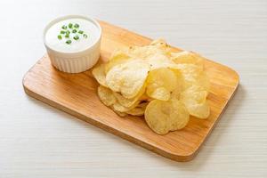 Potato chips with sour cream dipping sauce photo