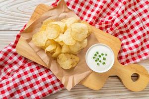 Potato chips with sour cream dipping sauce photo