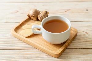 Fresh and hot ginger juice glass with ginger roots - Healthy drink style photo