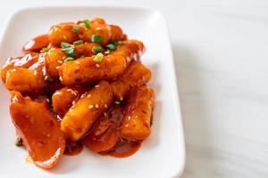 Korean rice cake stick with sausage in spicy sauce - Tteokbokki photo