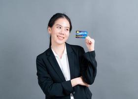 Portrait of a lovely young Asian woman showing credit card photo