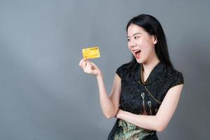 Asian woman wear Chinese traditional dress with hand holding credit card photo