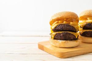 hamburguesas o hamburguesas de ternera con queso y papas fritas - estilo de comida poco saludable foto