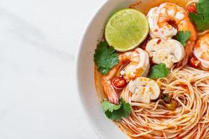 Noodles with spicy soup and shrimps in white bowl - Tom Yum Kung  - Asian food style photo