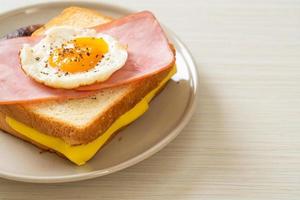 Homemade bread toasted cheese topped ham and fried egg with pork sausage and coffee for breakfast photo