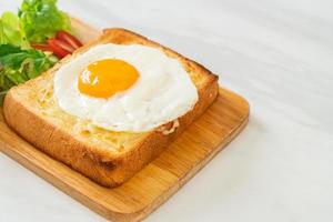 pan casero tostado con queso y huevo frito encima con ensalada de verduras para el desayuno foto