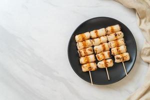 Grilled tube-shaped fish paste cake or tube squid skewer on plate photo