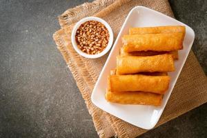 Deep-fried spring roll with sauce on white plate photo