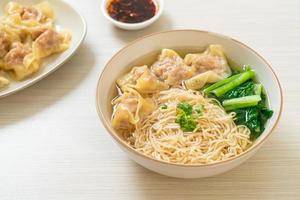 Egg noodles with pork wonton soup or pork dumplings soup and vegetable - Asian food style photo