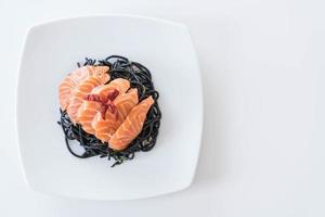 Spicy black spaghetti with salmon - fusion food style photo