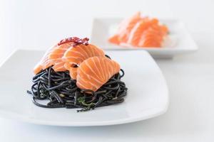 Spicy black spaghetti with salmon - fusion food style photo