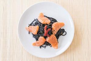 Spicy black spaghetti with salmon - fusion food style photo