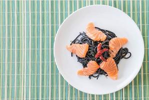 Spicy black spaghetti with salmon - fusion food style photo