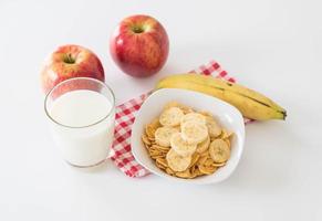 leche, manzana, plátano y hojuelas de maíz para el desayuno foto