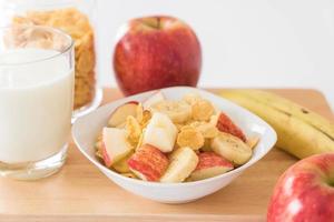 Milk, apple, banana, and cornflakes for breakfast photo