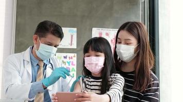 chica asiática tomando selfie con mamá mientras un médico está vacunando. video