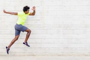 Black man training running jumps to strengthen his legs. photo
