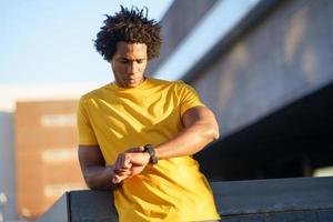 Black man consulting his smartwatch to view his training data. photo