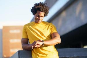 Black man consulting his smartwatch to view his training data. photo