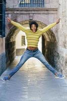 Black man with afro hair jumping for joy photo