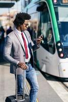 hombre de negocios negro vistiendo traje esperando su tren foto