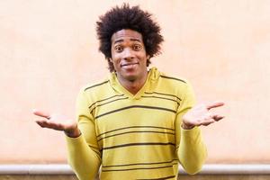 hombre negro con cabello afro poniendo una expresión divertida foto
