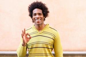 hombre negro con cabello afro poniendo una expresión divertida foto