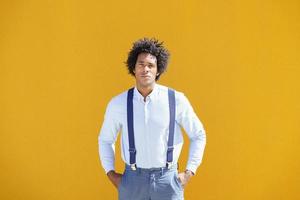 Hombre negro con pelo afro sobre fondo urbano amarillo foto