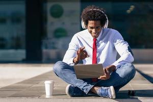 empresario negro con ordenador portátil y auriculares foto