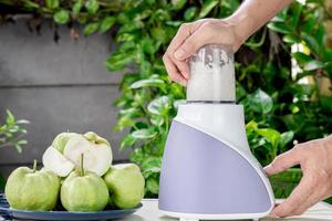 Using an electric blender to making fresh guava juice photo