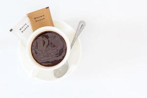 A cup of black coffee and sugar sachet for refreshing in the morning photo