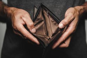 Close up of man hands holding and empty wallet. no money. photo