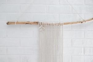 Woman knits weaving macrame pinned on a wooden stick photo