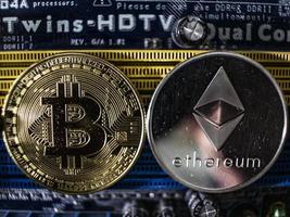 Coins of ethereum and bitcoin on the background of the chip photo