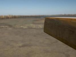 handmade wooden coffee table corner on blue sky and sand background photo