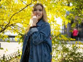 Linda chica rubia con cabello suelto en una chaqueta de jeans foto