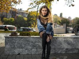 attractive girl with beautiful flowing hair sits on a bench photo