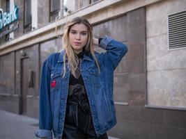 Chica atractiva con un cabello precioso en una chaqueta de mezclilla foto