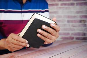 close up of young man hand reading a book photo