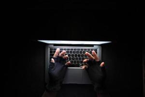 hacker hand stealing data from laptop top down photo