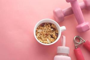 cereal breakfast in bowl and pink color dumbbell on table photo