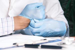 man doctor wears medical gloves, close up photo